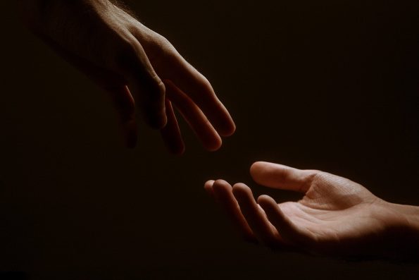 Two hands reaching toward each other